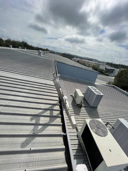 commercial building's roof with vents and cooler. Commercial gutter cleaning