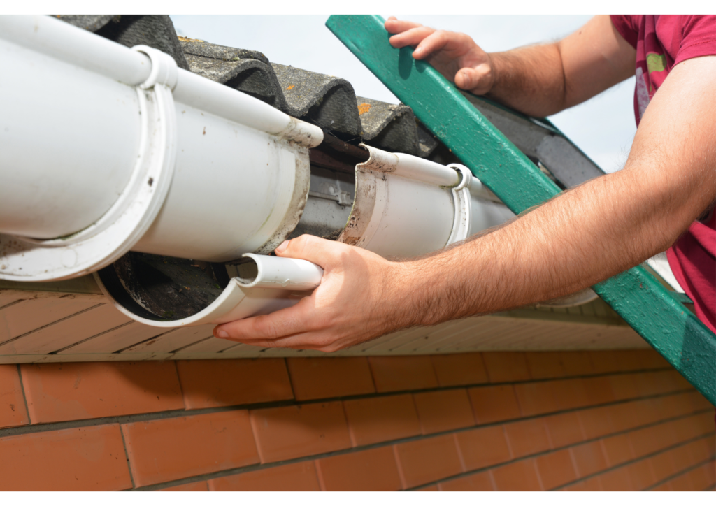 worker repairing a white gutter while standing on a ladder
