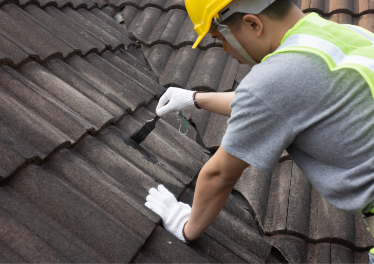 worker doing a roof maintenance by putting roof leak sealant